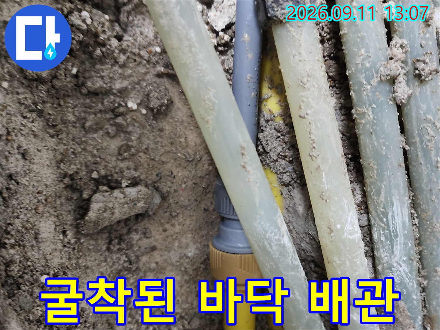흙과 모래 사이로 드러난 누수 의심 배관 부위