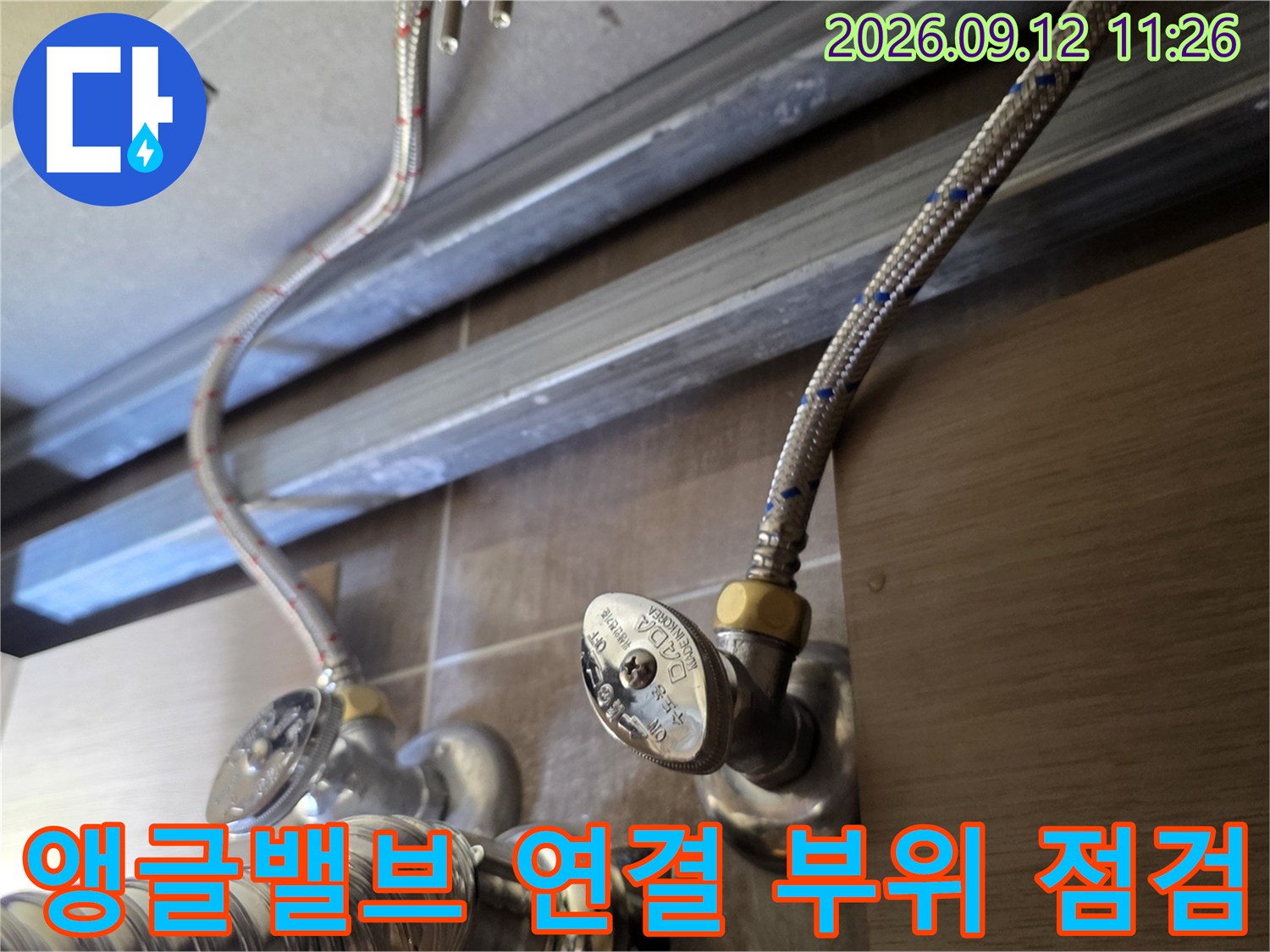 금속 재질의 앵글밸브와 유연한 급수 호스가 연결된 모습입니다.