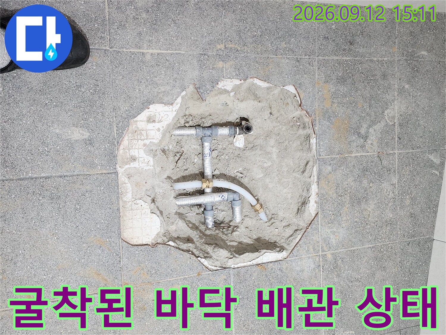 타일 굴착 후 드러난 노출된 수도 배관과 연결 부속들