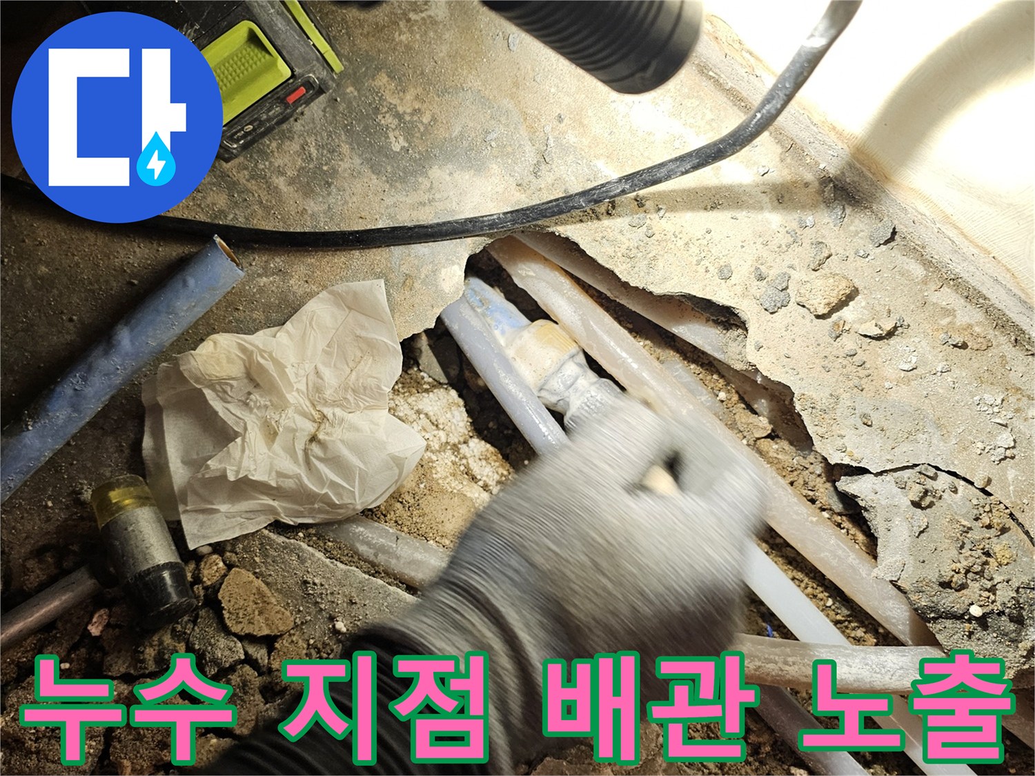 배관 연결 부위의 결함으로 인해 물이 새어 나오는 굴착 현장 사진입니다.