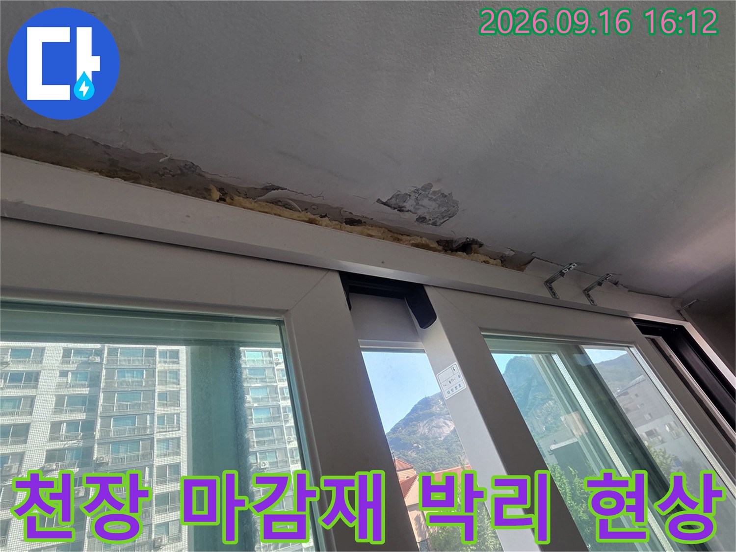 창틀 상단 천장 마감재가 벗겨지고 콘크리트가 노출된 사진입니다