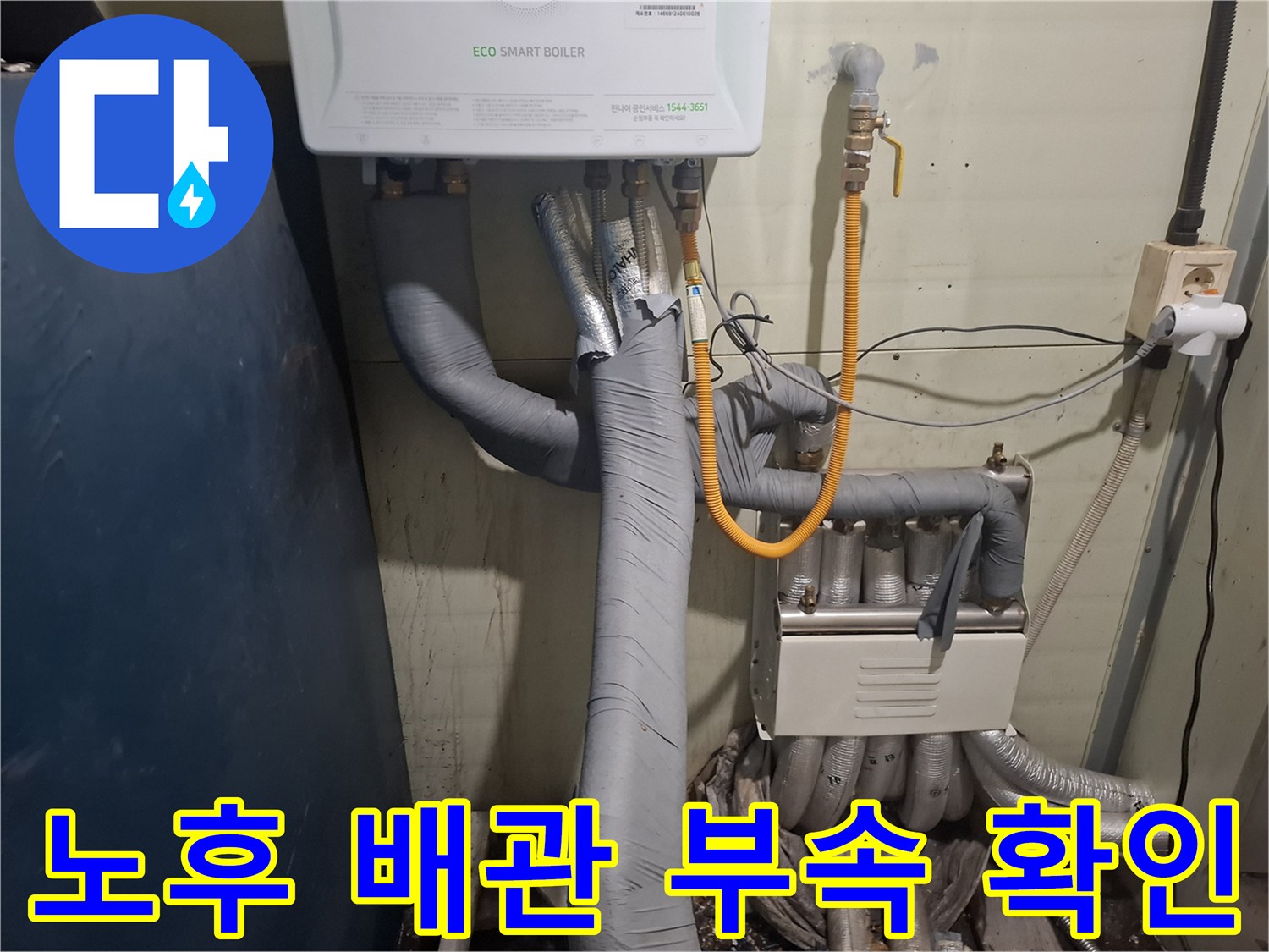 회색 보온재로 감싸진 보일러 배관과 노란색 호스 연결 상태