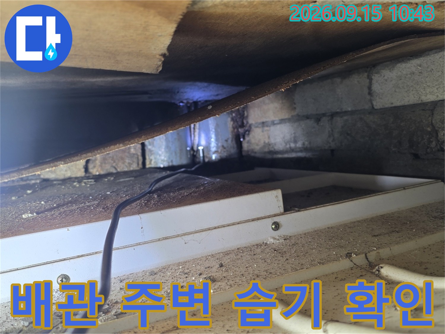 콘크리트 벽면과 배관 사이의 누수 흔적을 추적하는 장면입니다.