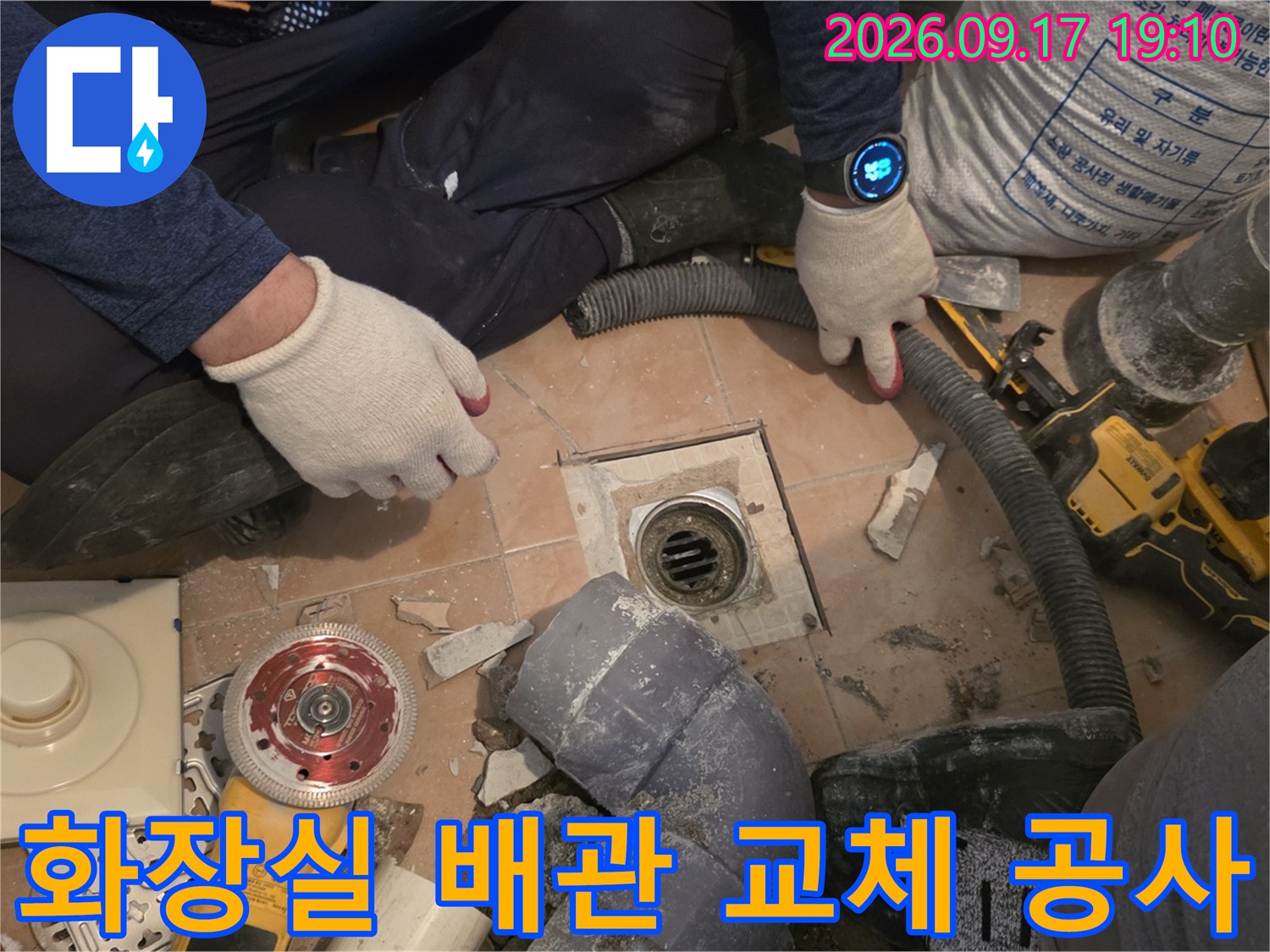 공사 중인 화장실 바닥의 굴착 부위와 작업에 사용되는 전동 드릴 및 장비들입니다.