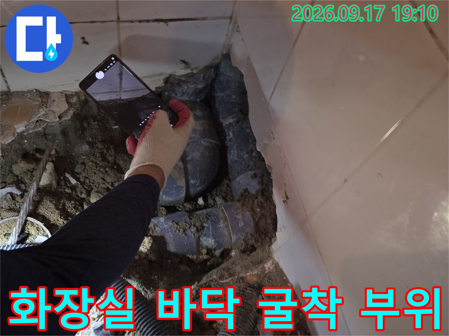 바닥 타일 제거 후 드러난 하수 배관과 주변 흙의 상태