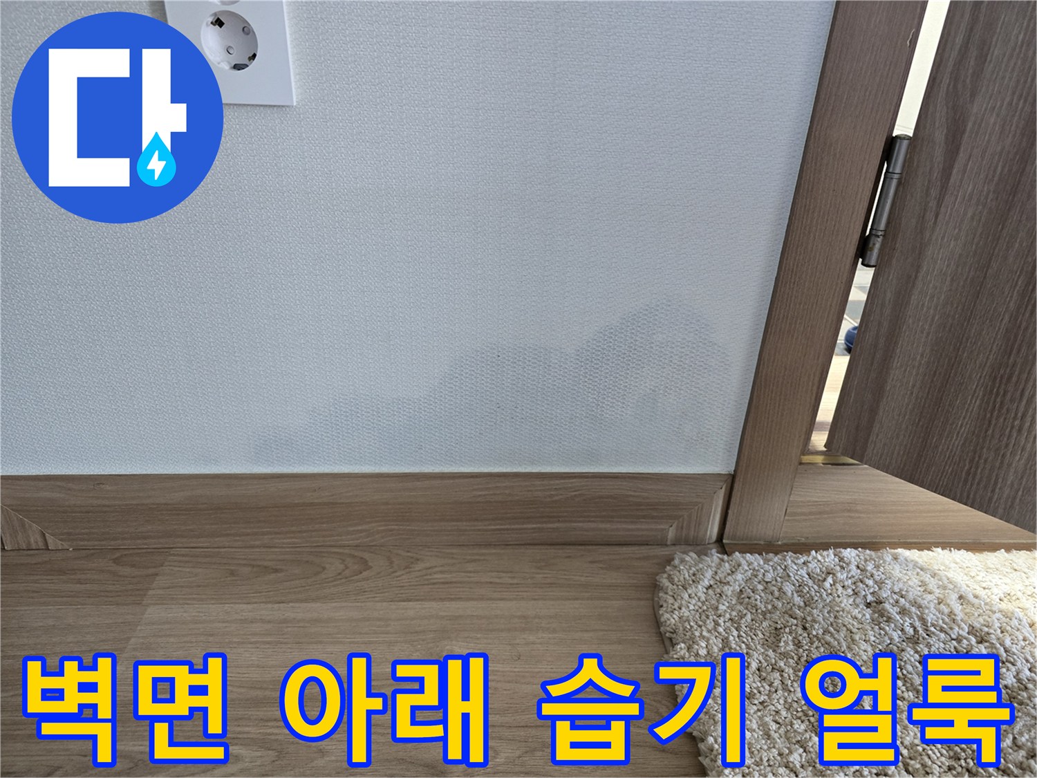거실 벽지와 걸레받이 경계 부분의 습기 침투 흔적