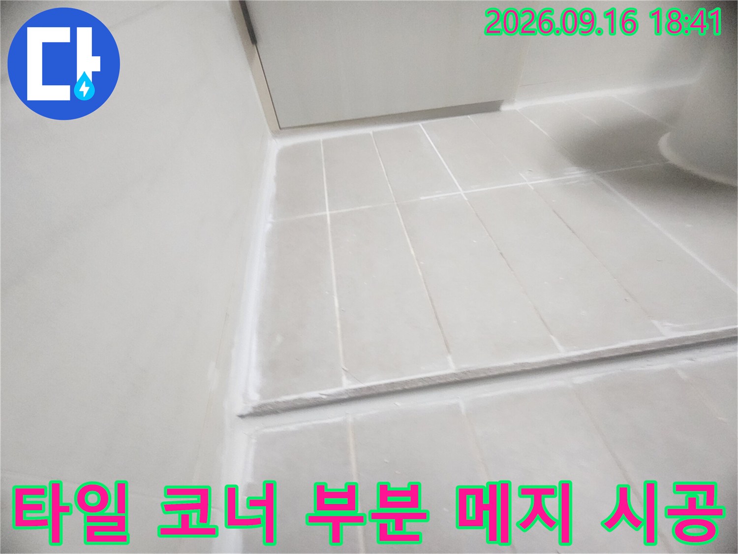 욕실 바닥과 벽면이 만나는 모서리 틈새를 메지로 마감하는 장면입니다.