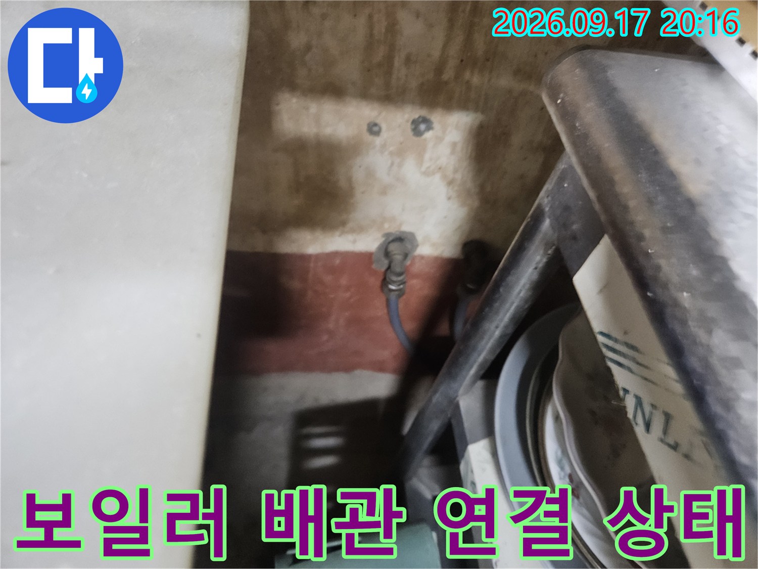 보일러 본체와 연결된 파란색 배관의 결합 부위를 촬영한 사진입니다.