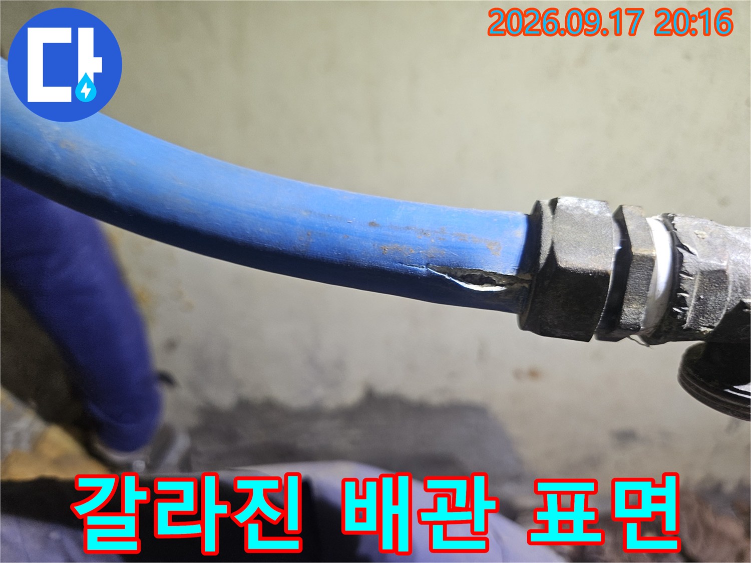 파란색 배관의 갈라진 틈 - 누수가 진행 중인 배관 손상 부위