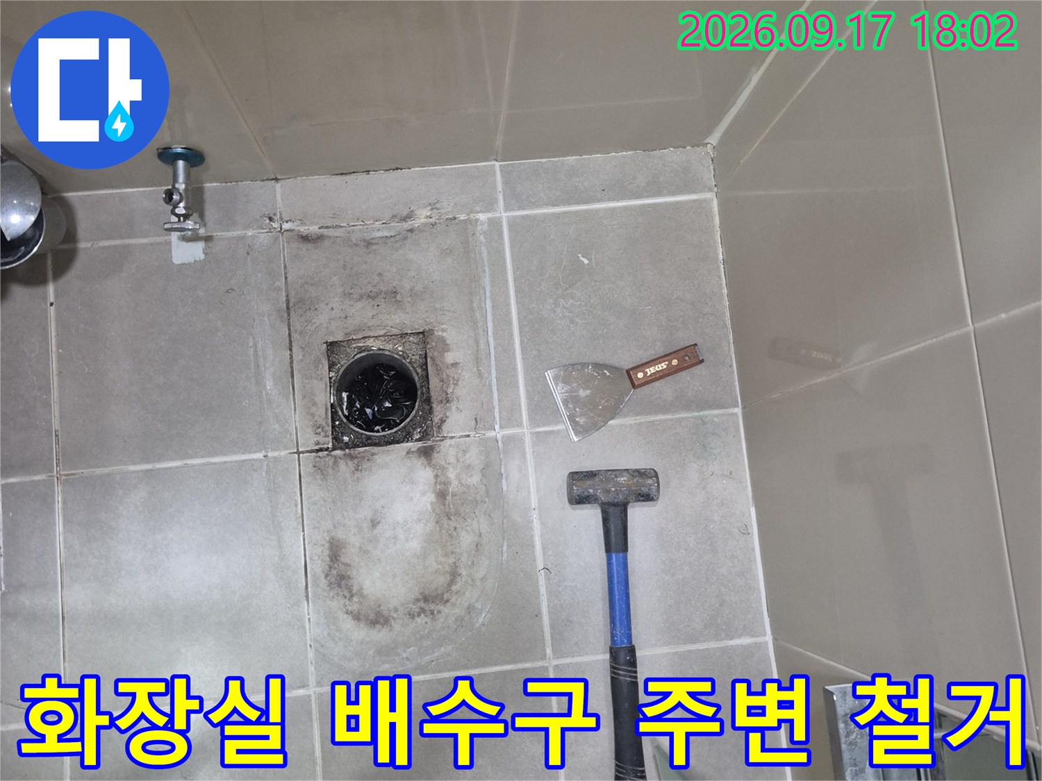 누수 확인을 위해 타일을 제거하고 배수 트랩을 드러낸 작업 현장의 모습입니다.