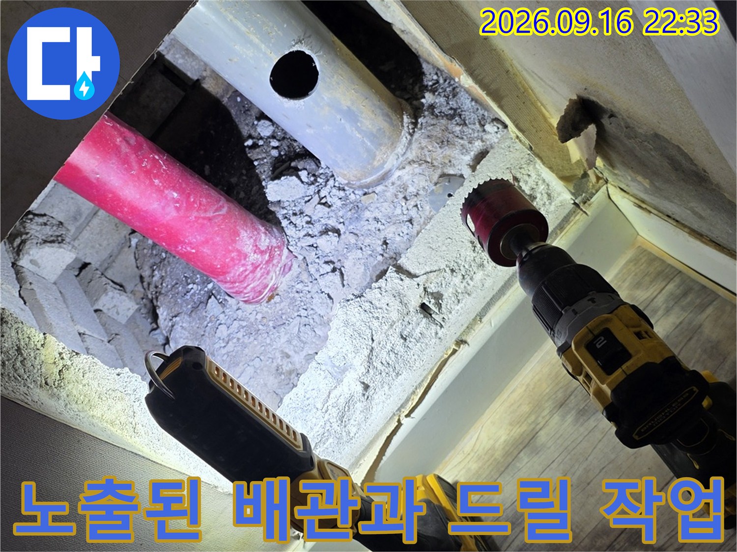 굴착된 벽면 내부에 보이는 분홍색 및 흰색 배관-누수 지점 확인을 위한 공사 현장입니다.