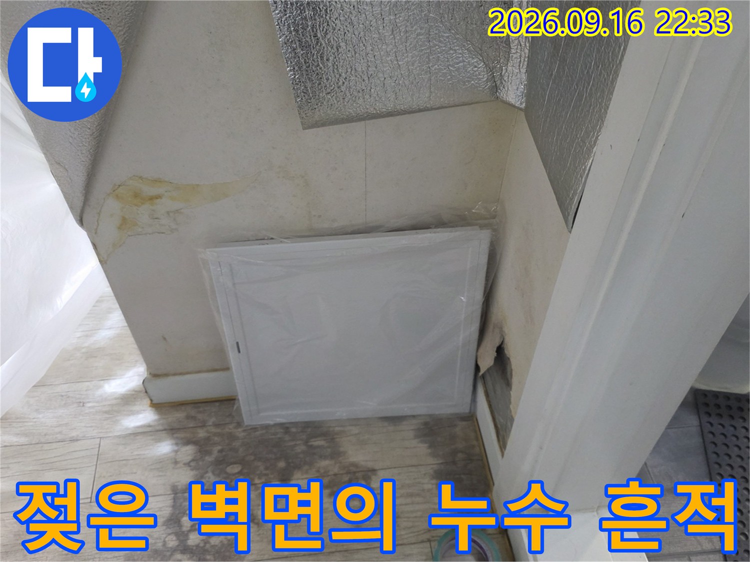 벽면 하단에 나타난 짙은 색의 누수 얼룩