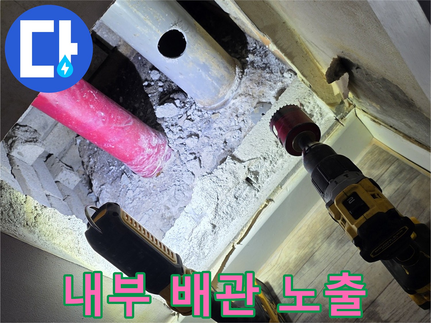 벽을 뚫어 드러난 분홍색 및 회색 배관의 교차 지점