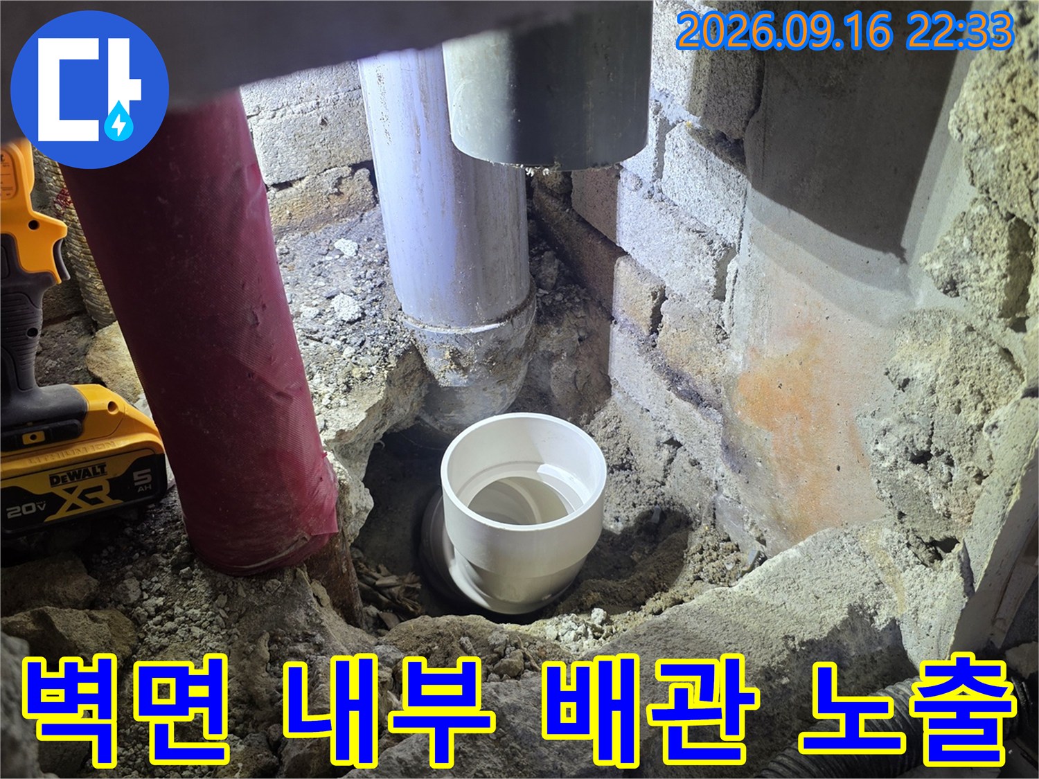 벽체 굴착 후 드러난 배관과 주변의 젖은 벽돌