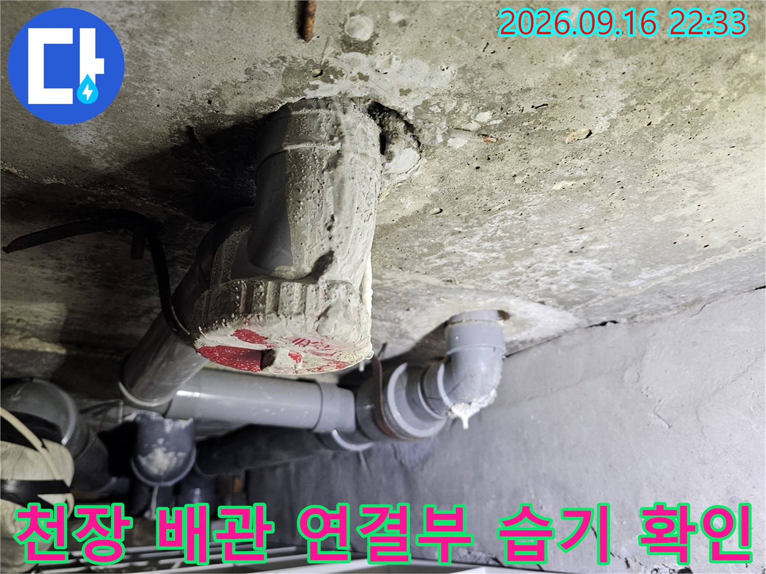 점검구 안쪽의 젖은 콘크리트와 배관의 위치 관계