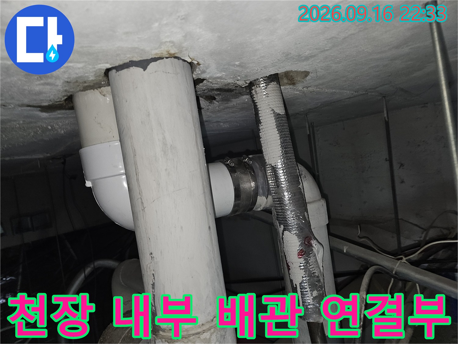 천장 마감재를 통과하여 내려오는 흰색 배관들의 연결 부위 사진입니다.